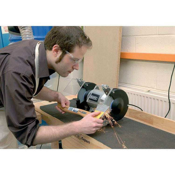 Draper 6" 250W bench grinder with black dual grinding wheels, wheel guards and adjustable eye shields in use