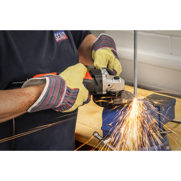 Sealey 115mm angle grinder with black and orange body cutting metal, producing bright sparks